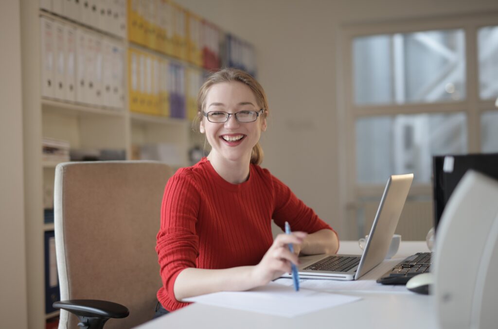 Professional woman in medical field smiling on computer